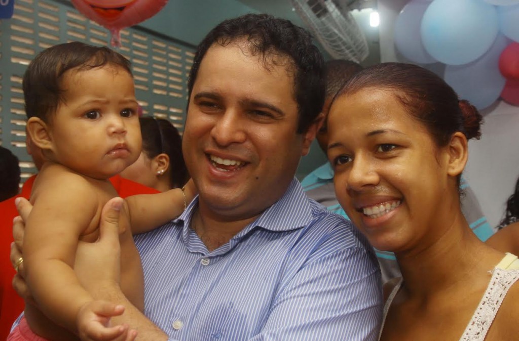 Edivaldo carrega bebê imunizado contra o Sarampo